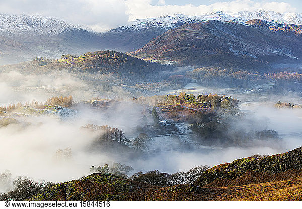 Looking down into the Langdale Valley above valley mist formed by a temperature inversion on Loughrigg  near Ambleside in the Lake District National Park.