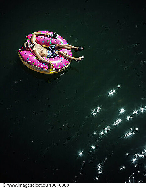 Looking down on a man floating on a inflatable inner tube.