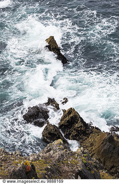 Looking down on a rocky cliff with waves crashing on rocks; Dingle  County Kerry  Ireland