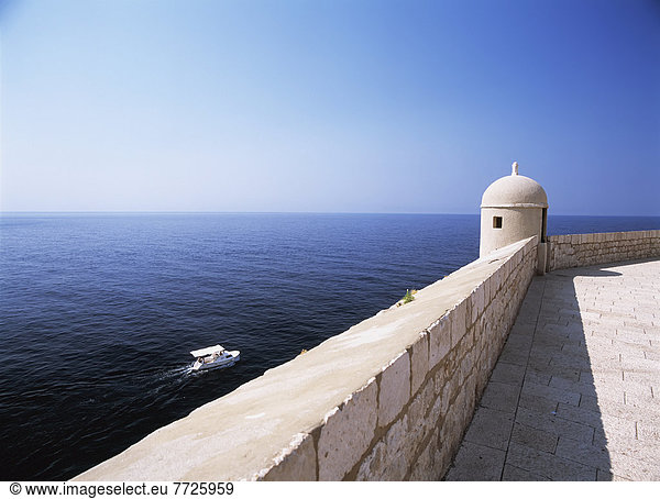 Looking out to sea and to small boat beneath the city walls of Dubrovnik  Croatia. . © Ian Cumming / Axiom