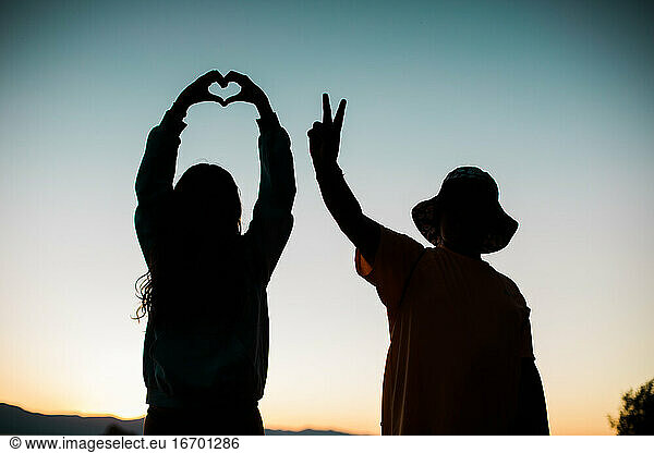 Love and Peace Sign Silhouettes with Colorful Sky - Young People