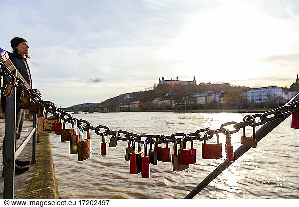 Love padlocks hanging on Main river against sky
