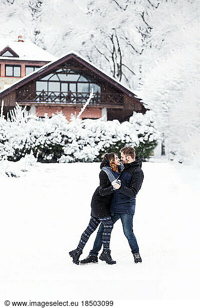 Loving couple dancing in the snowy park