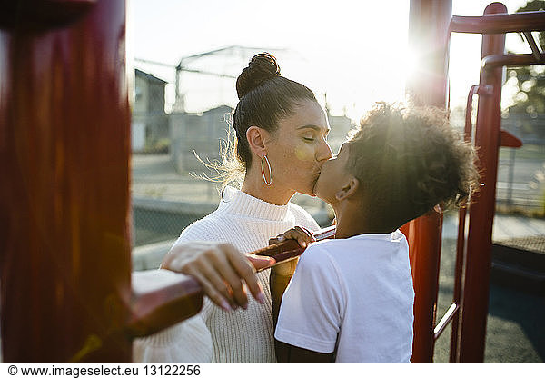 Loving mother and son kissing on mouth at playground
