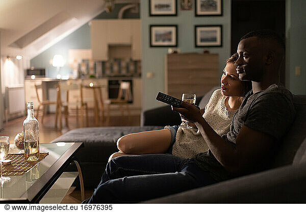 Loving multiracial couple watching movie during date