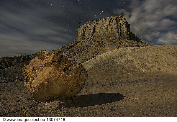 Low angle scenic view of rock formation against cloudy sky at Grand Staircase-Escalante National Monument during night