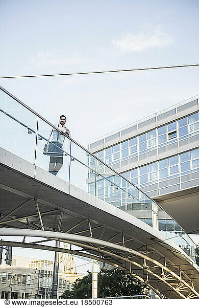 Low angle view of a businessman standing on bridge  Munich  Bavaria  Germany