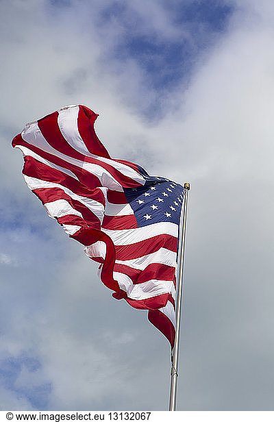 Low angle view of American flag against cloudy sky