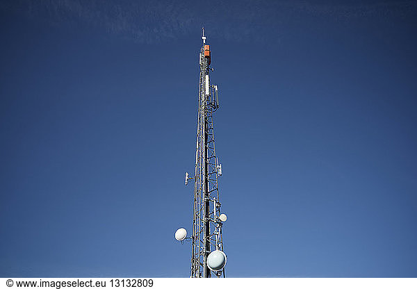 Low angle view of Communications tower against blue sky during sunny day
