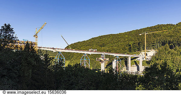 Low angle view of constructing railway bridge amidst mountains against clear blue sky  Wiesensteig  Germany
