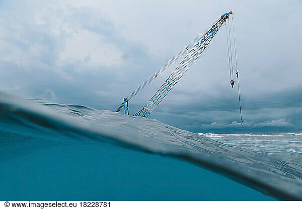 Low angle view of crane at ocean coast