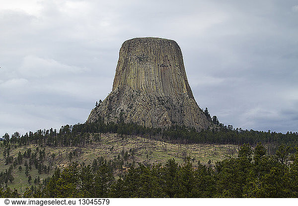 Low angle view of Devils Tower National Monument against cloudy sky