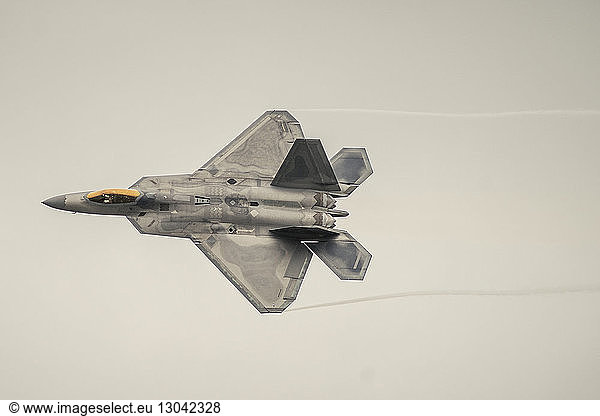Low angle view of fighter plane flying in sky