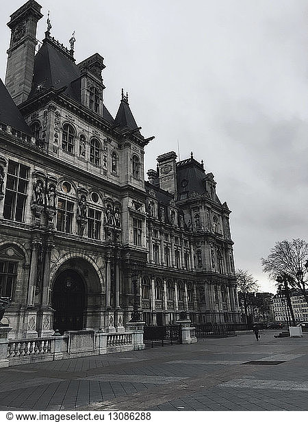 Low angle view of Hotel de Ville against cloudy sky