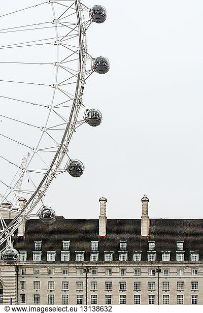 Low angle view of London Eye and County Hall against sky