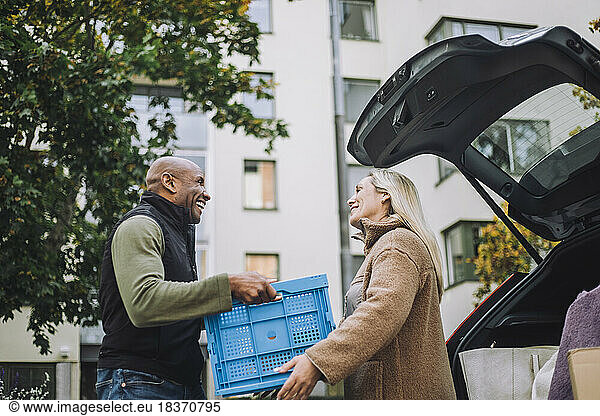 Low angle view of mature man giving crate to woman