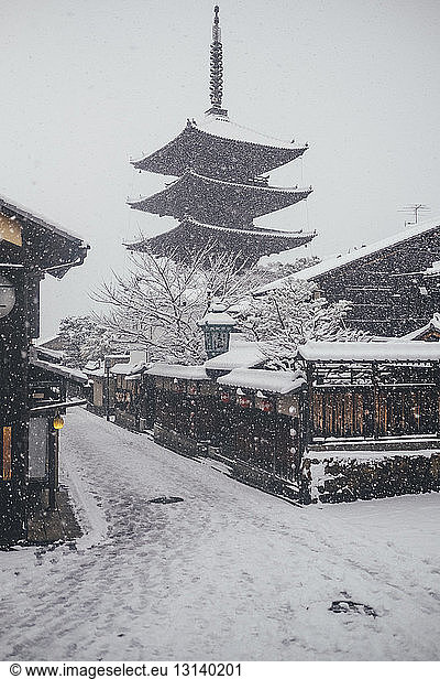 Low angle view of pagoda against clear sky during snowfall