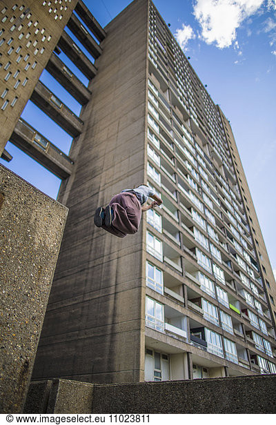 Low angle view of person jumping against building