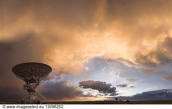 Low angle view of satellite dish against cloudy sky during sunset