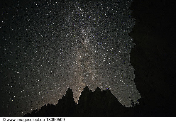 Low angle view of silhouette rock formations against sky with star field at Smith Rock State Park