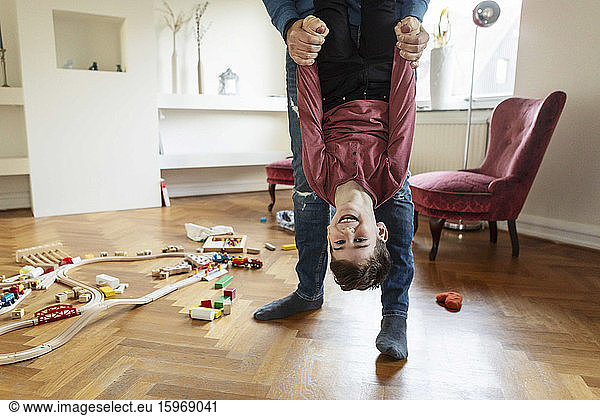 Low section of father lifting son in living room
