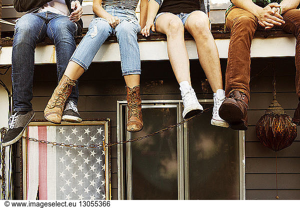 Low section of friends sitting on roof