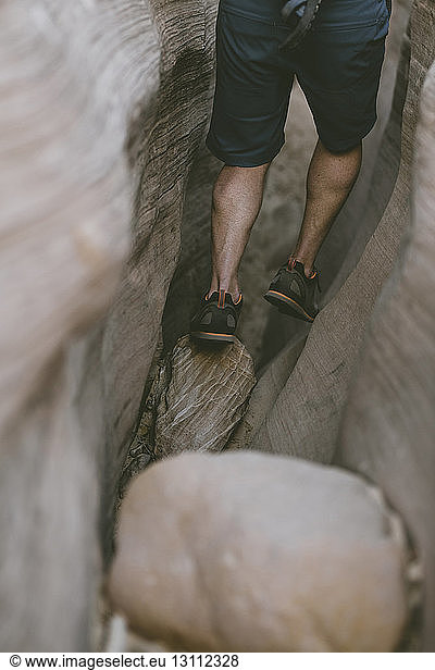 Low section of hiker canyoneering amidst narrow canyons