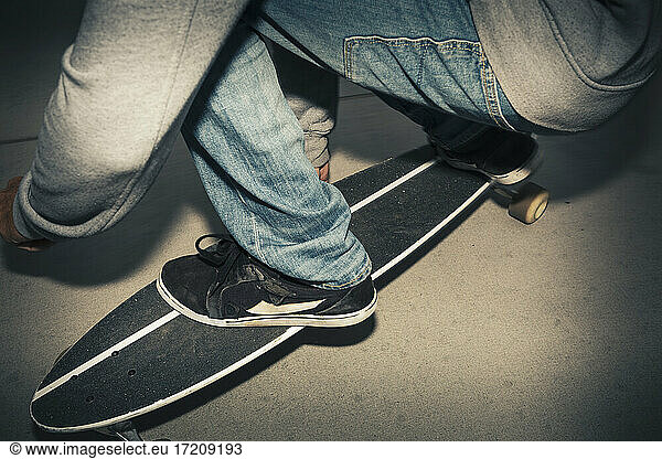 Low section of man squatting on skateboard