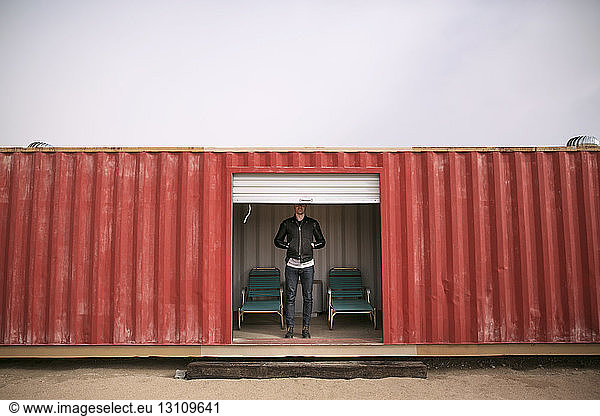 Low section of man standing in red container