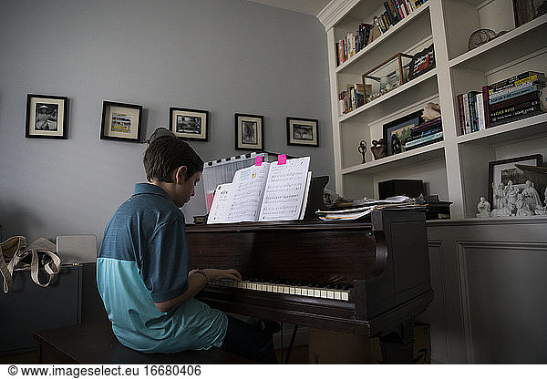 Low Side View of Teen Boy Playing Piano at Home from Marked Pages