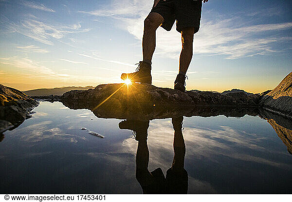 Lower half view of hiker wearing boots on mountain summit