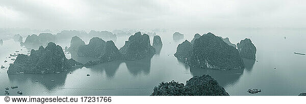 Luftaufnahme über die neblige Ha Long Bucht und hohe Felssäulen