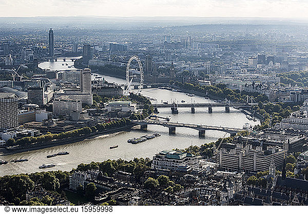 Luftaufnahme der City of London und der Themse im Westen  mit Wahrzeichen wie dem London Eye und Dächern.