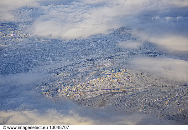 Luftaufnahme der Wolken  die die schneebedeckte Landschaft bedecken