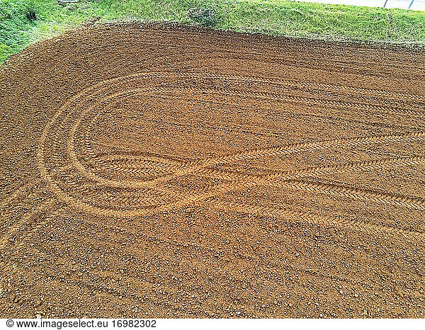 Luftaufnahme eines gepflügten landwirtschaftlichen Feldes mit den Spuren eines Fahrzeugs