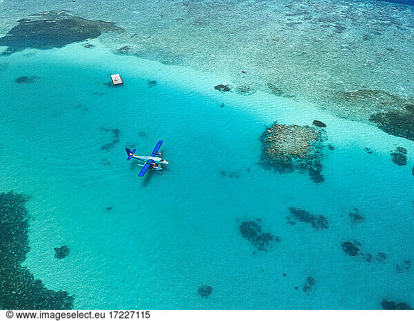 Luftaufnahme eines Wasserflugzeugs  das im türkisfarbenen Wasser des Male-Atolls schwimmt