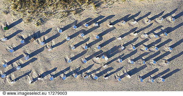 Luftaufnahme von Reihen von Strandkörben mit Kapuze am Sandstrand