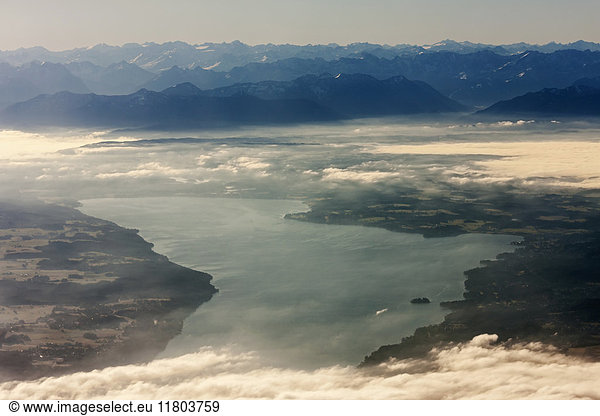 Luftaufnahme von silhouettierten Bergkette durch Fluss mit Landschaft und Wolken