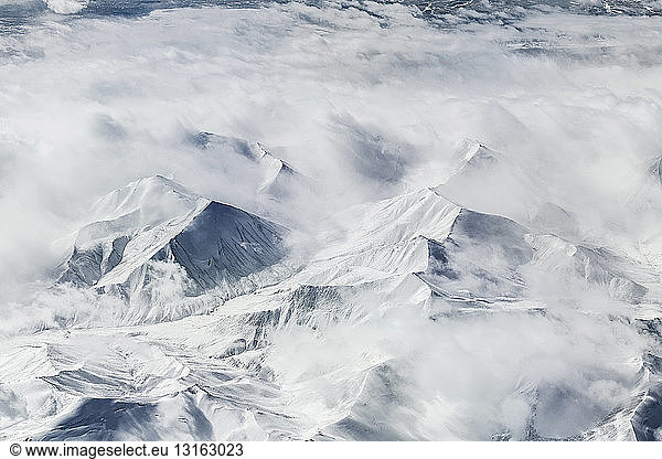 Luftaufnahme von wolken- und schneebedeckten Bergen  Westchina  Ostasien