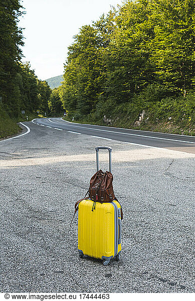 Luggage left on side of empty road in Plitvice Lakes National Park