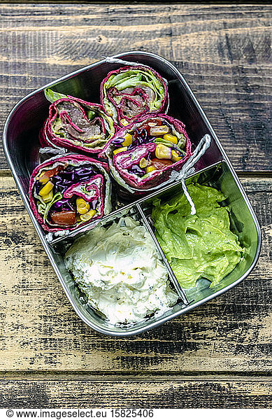 Lunch box containing beetroot wraps  cream cheese and guacamole