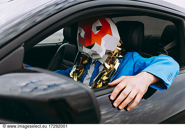 Lustige Figur mit Tiermaske und blauem Geschäftsanzug im Auto