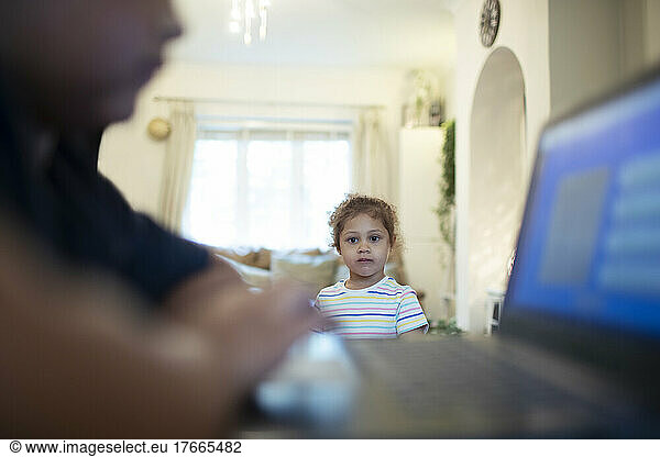 Mädchen beobachtet Bruder mit Laptop