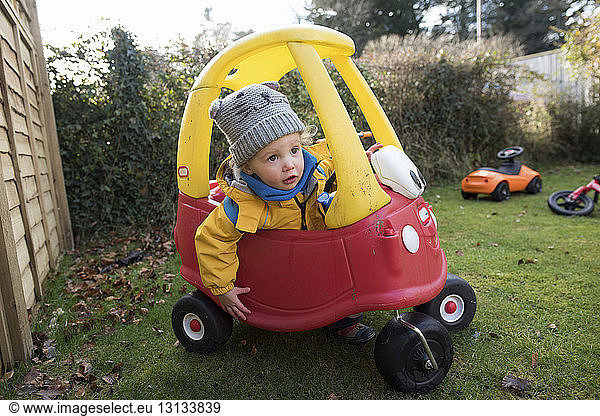 Mädchen fährt Spielzeugauto im Hinterhof