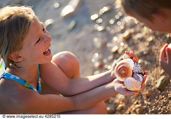 Mädchen finden Muscheln am Strand