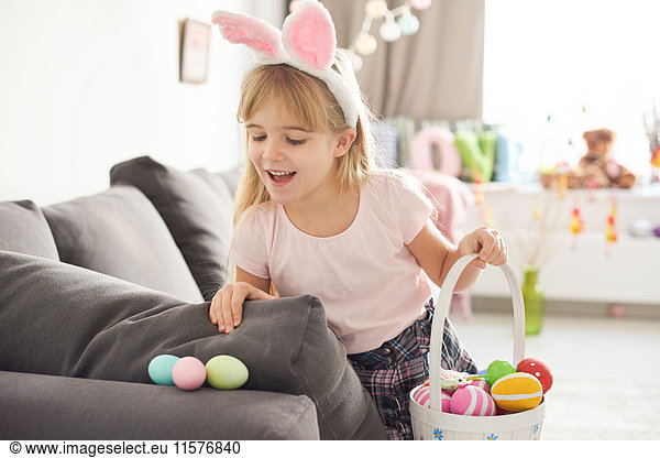 Mädchen findet Ostereier auf Sofa