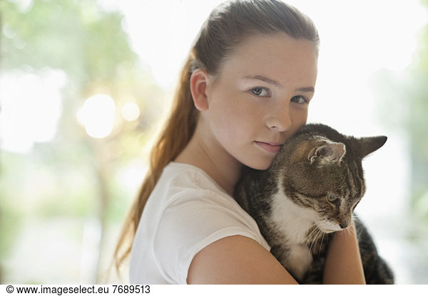 Mädchen hält Katze im Haus