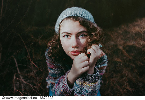 Mädchen im Wald mit Hut und Pullover