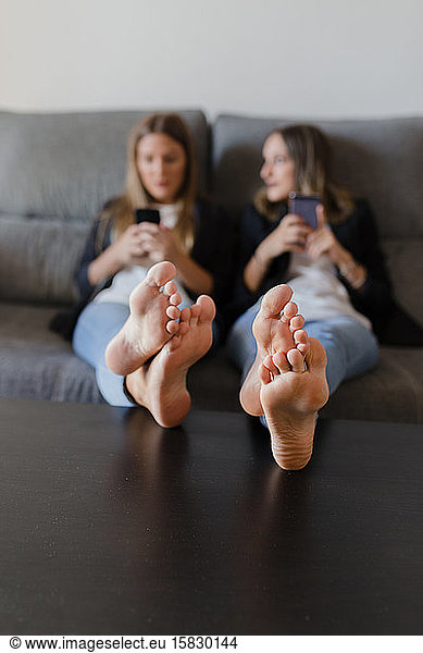 Mädchen in einer Couch mit Füßen auf einem Tisch