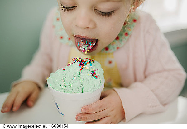Mädchen isst Eiscreme mit Streuseln